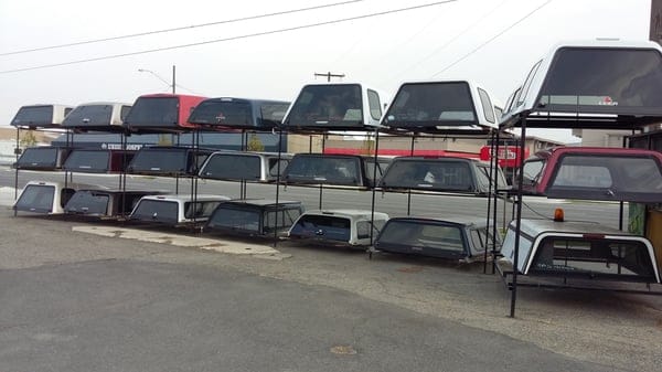 Racked truck toppers outside the shop