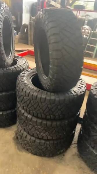 Mud-terrain tires stacked in the shop