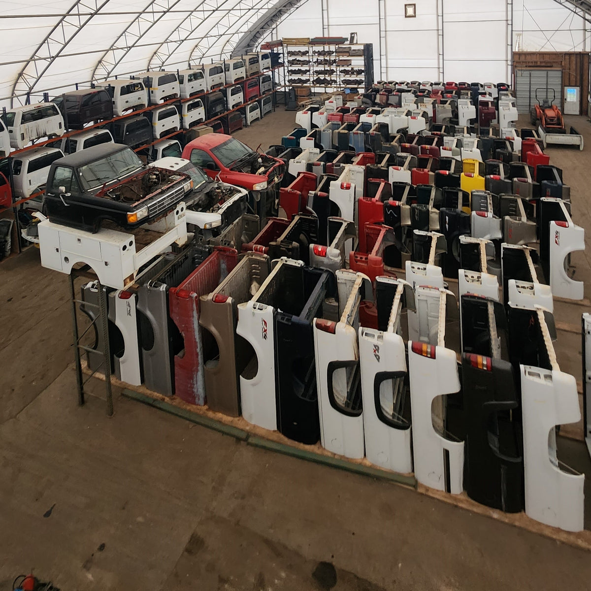 Inside the warehouse — rows of truck boxes and cabs